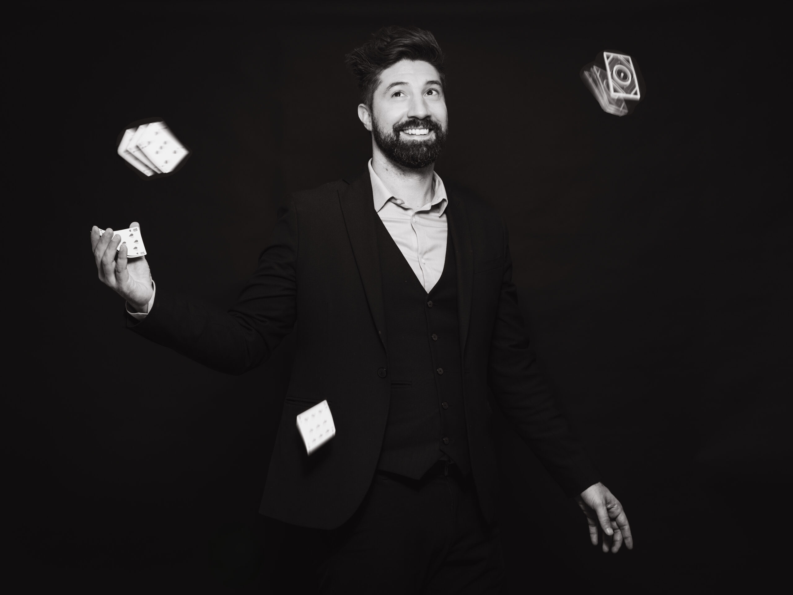Magicien en costume jongle avec des cartes dans une mise en scène artistique
